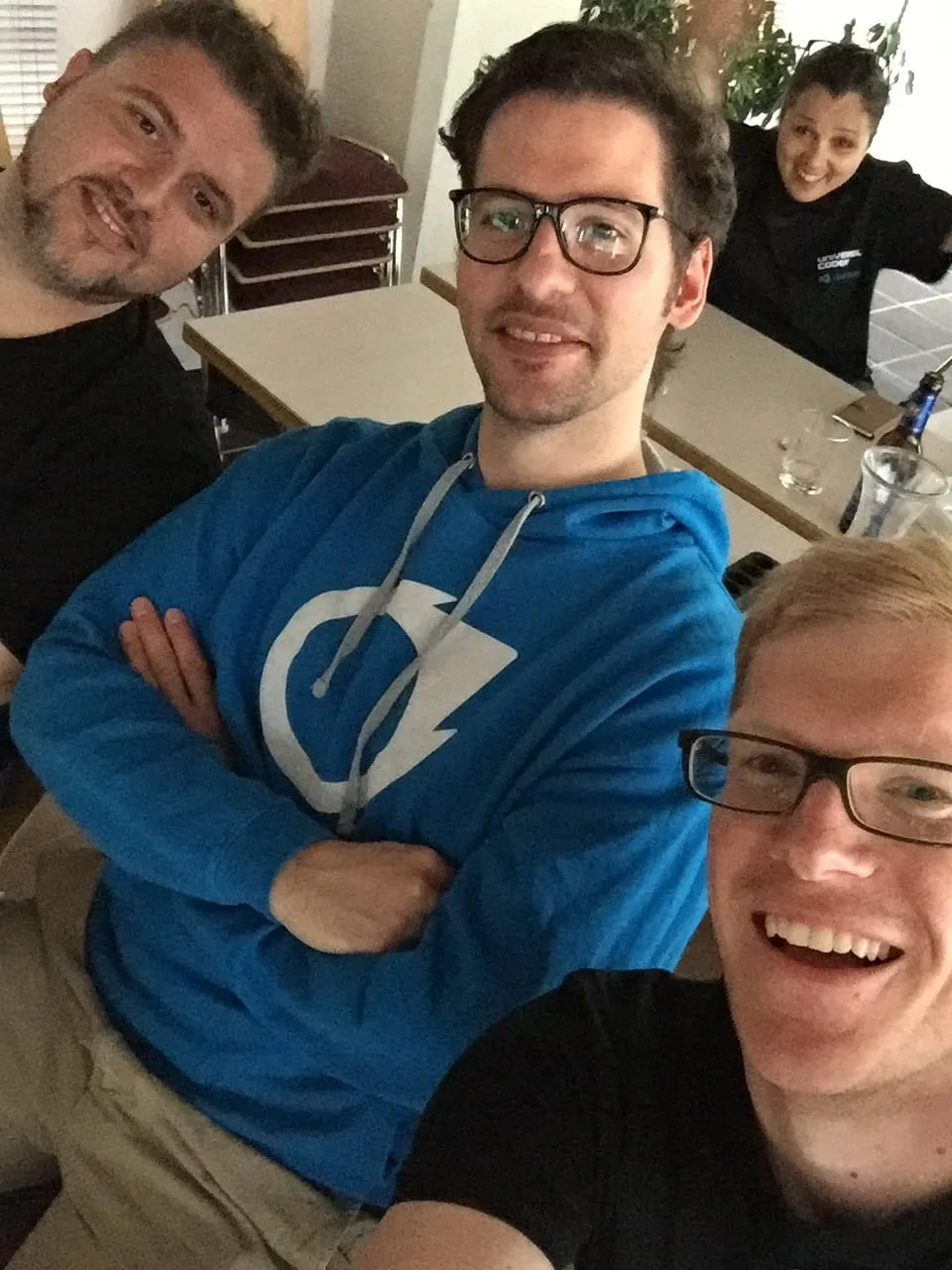 Selfie zu viert am Tisch, in der Mitte ein Kapuzenpulli mit dem früheren xappido-Logo