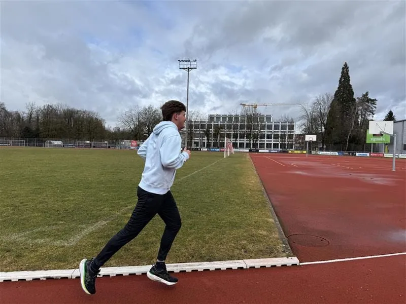 Lauftraining auf der Rundbahn eines Sportplatzes
