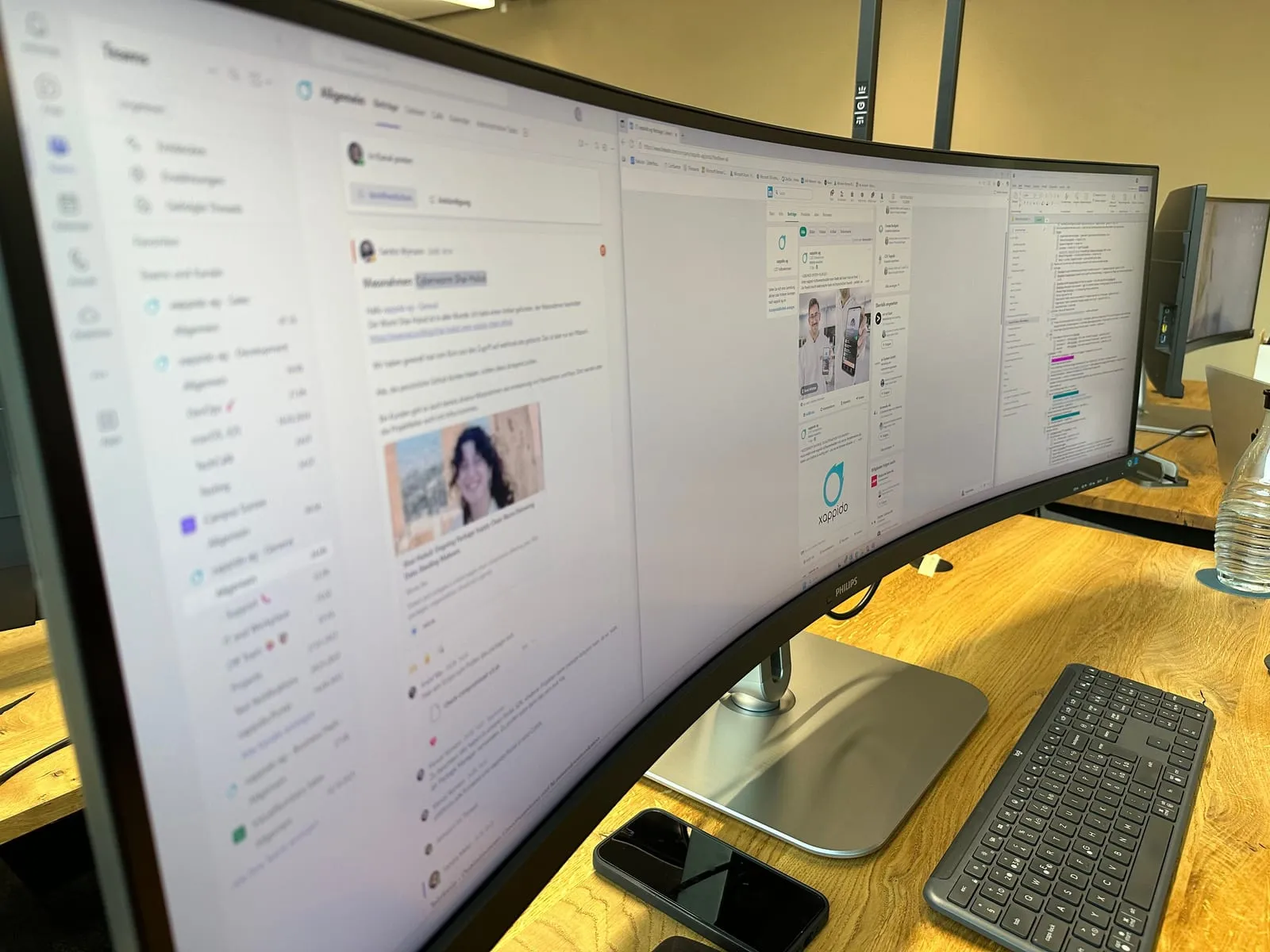 Breitbildmonitor mit geöffnetem Teams-Chat am Arbeitsplatz