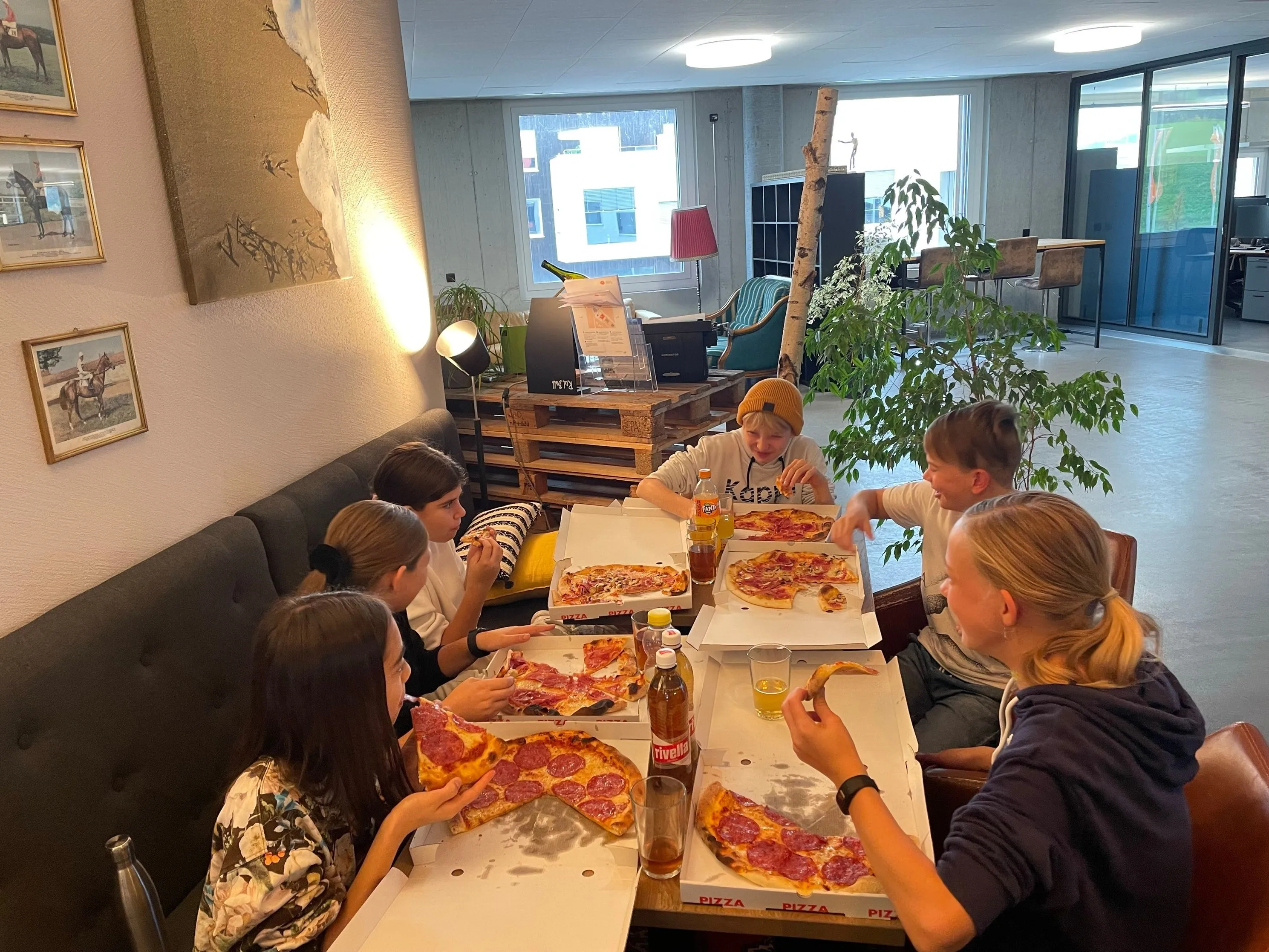 Gemeinsame Pizza-Pause am langen Tisch