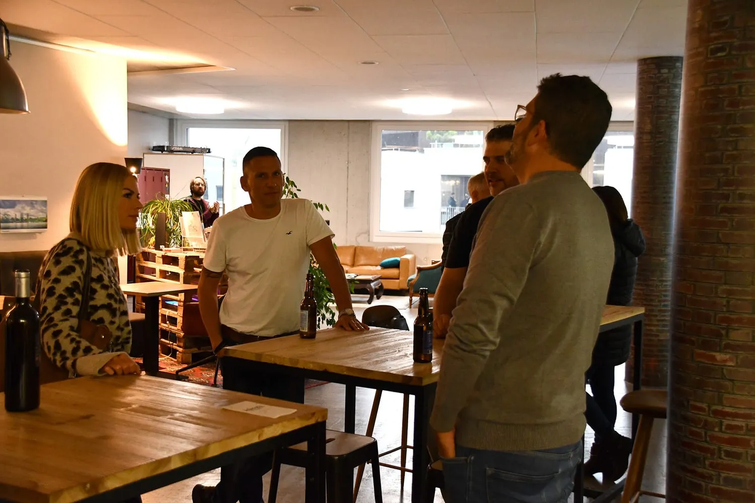 Gruppen im Gespräch zwischen den Betonsäulen des Coworking Space