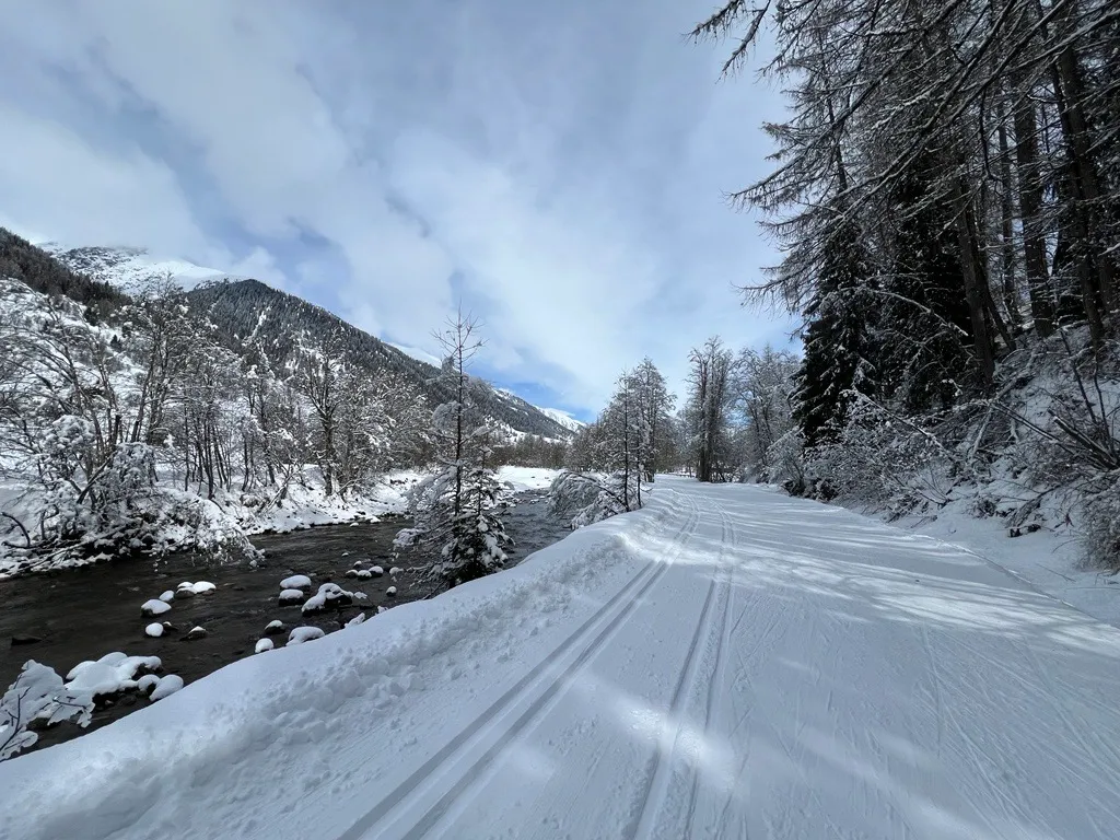 Winterlandschaft mit Bach und schneebedeckter Strasse